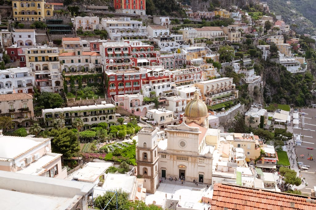 A breathtaking view of Positano, Italy, showcasing vibrant buildings and the Church of Santa Maria Assunta along the Amalfi Coast.