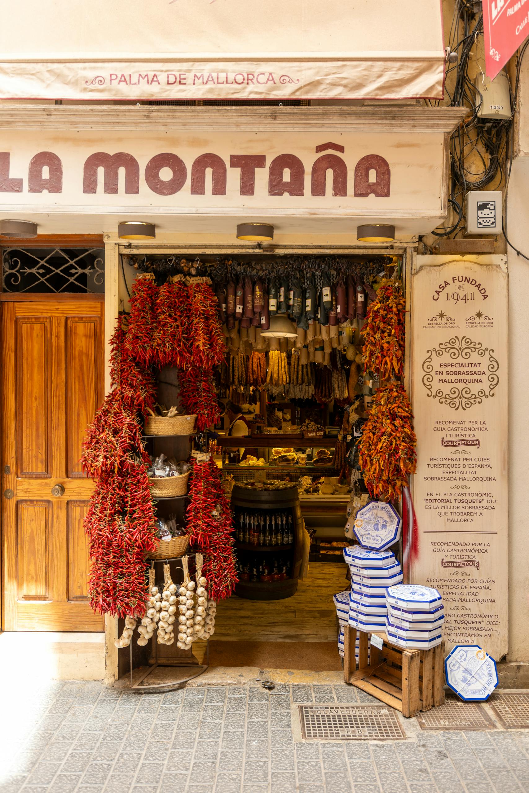 Charming traditional store in Palma, Spain, featuring vibrant peppers and authentic pottery.