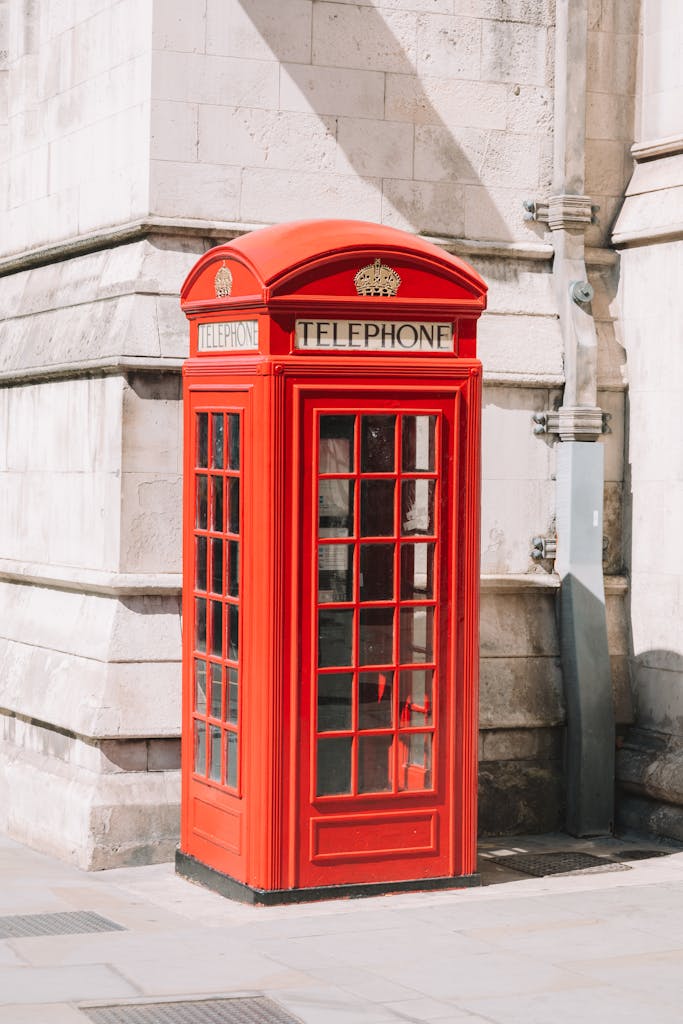 Classic red telephone box on a street corner in London, UK.