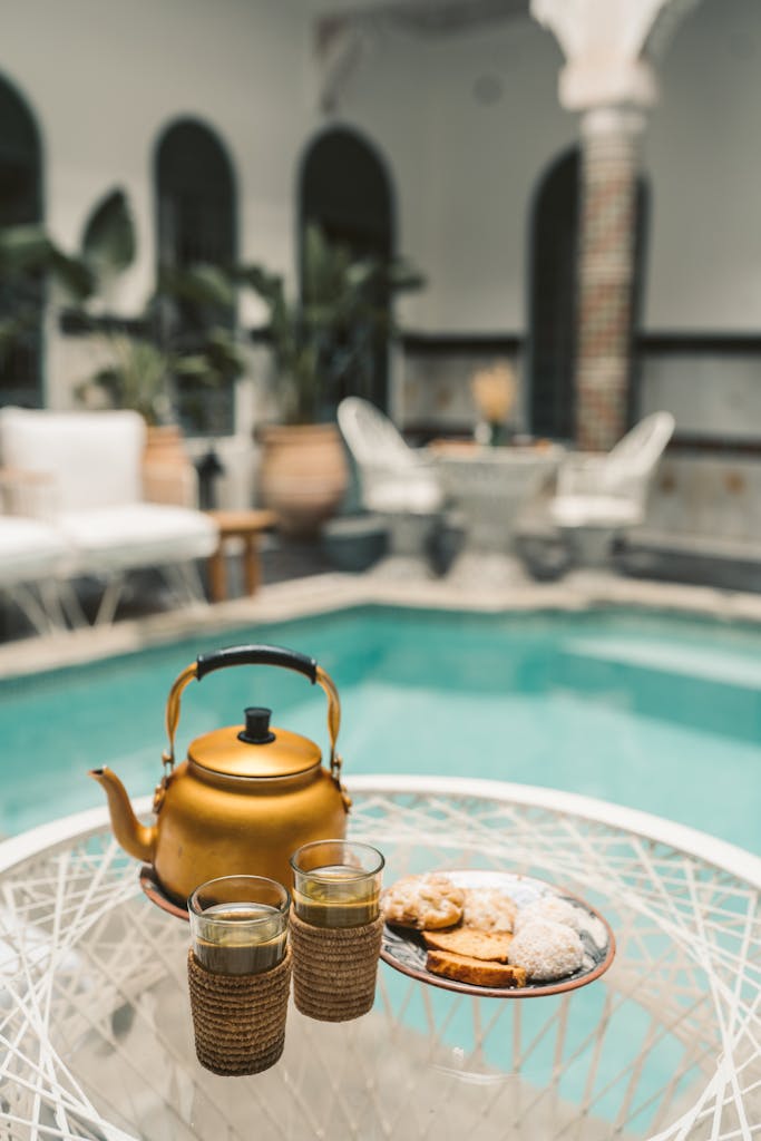 Experience traditional Moroccan tea and sweets by a stylish poolside in Marrakesh.
