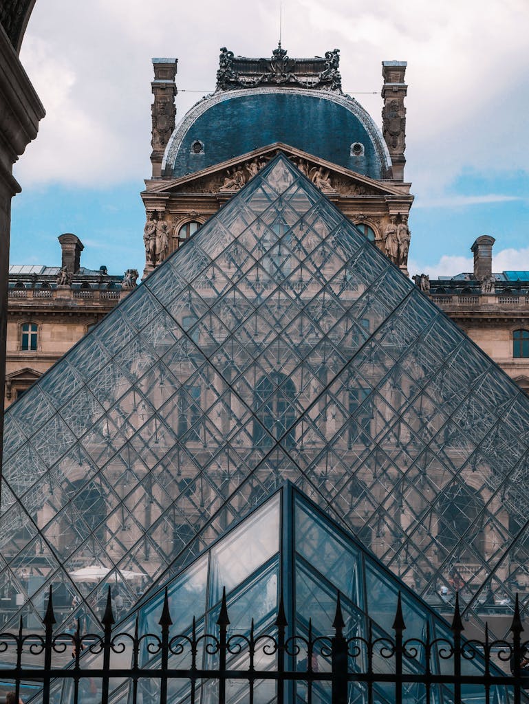 Iconic Louvre Pyramid against historical building in Paris, France.