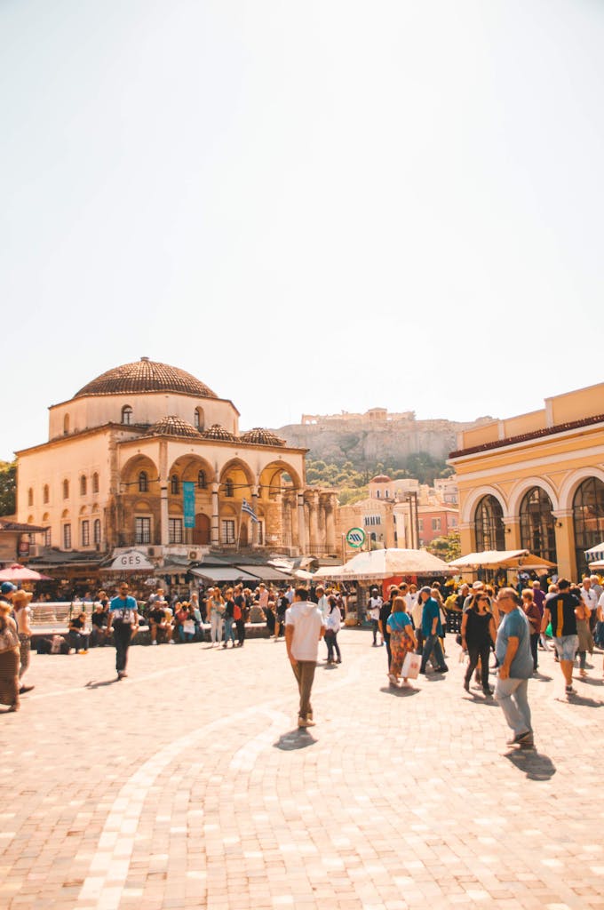 Lively scene at Monastiraki Square in Athens with people enjoying a sunny day, historic architecture in view.