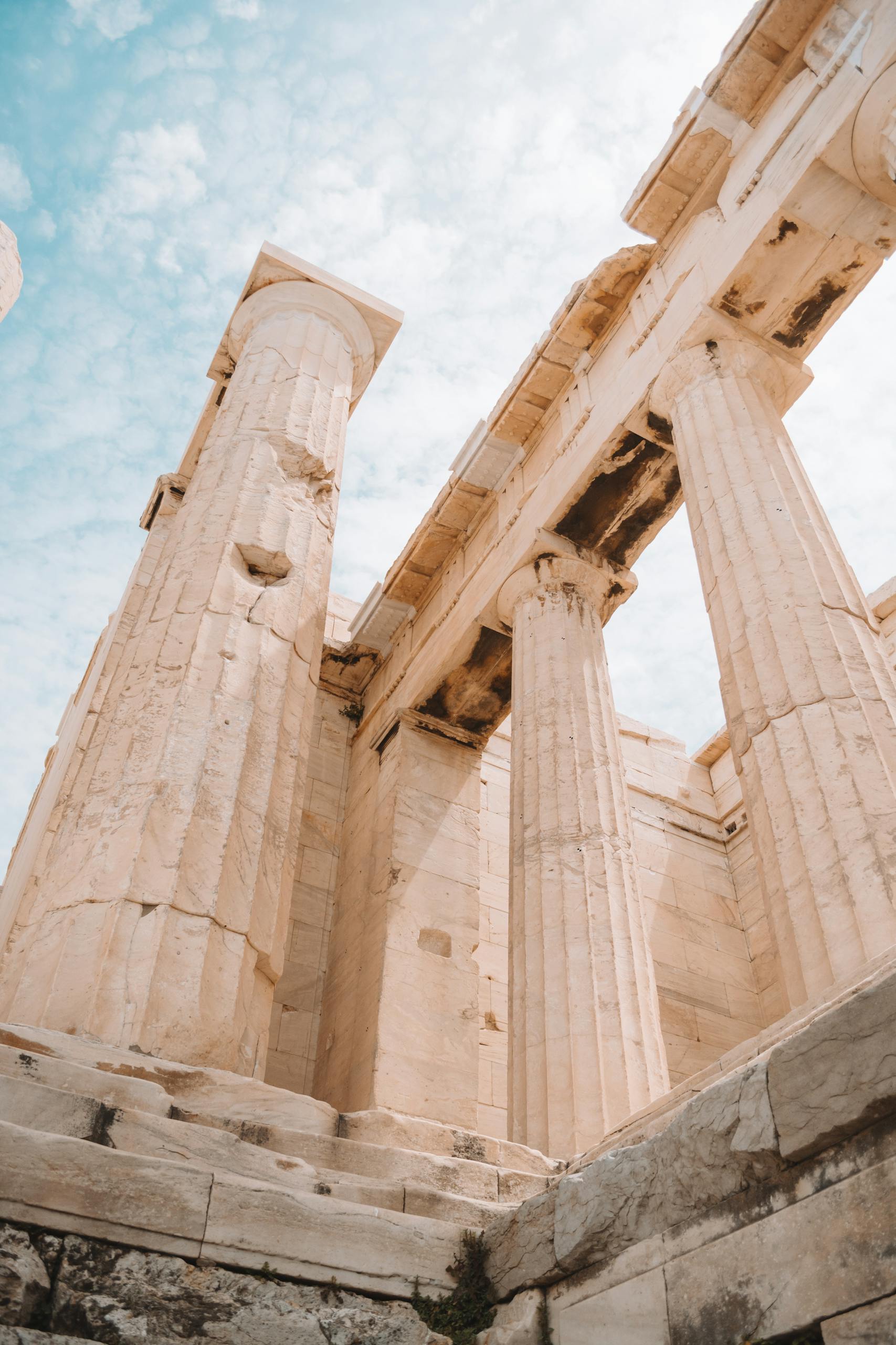 Low angle shot of the ancient Parthenon columns in Athens, Greece, against a clear blue sky.