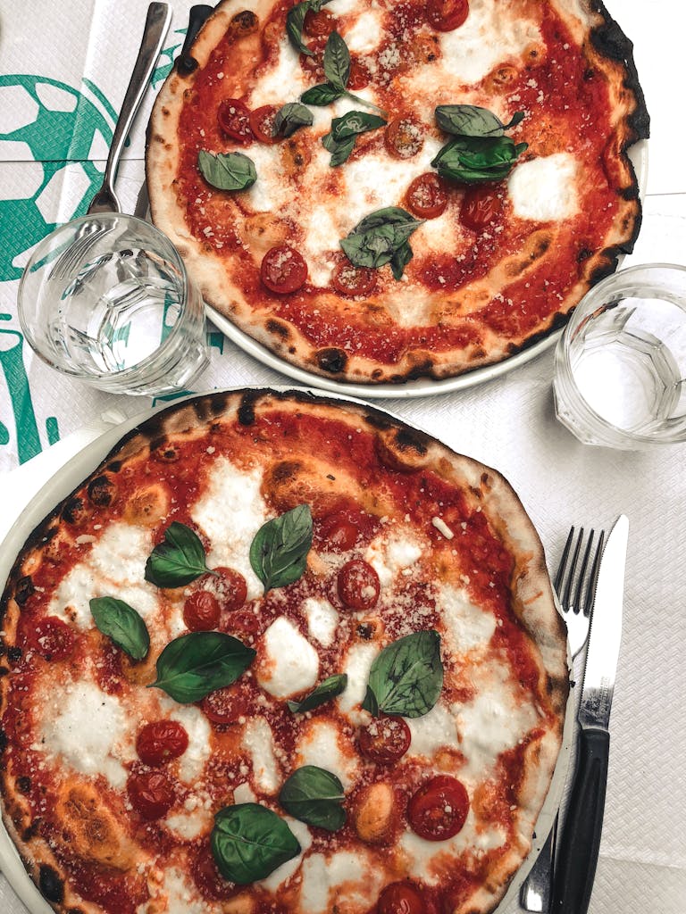 Two delicious pizzas topped with mozzarella and basil, perfect for a tasty meal.
