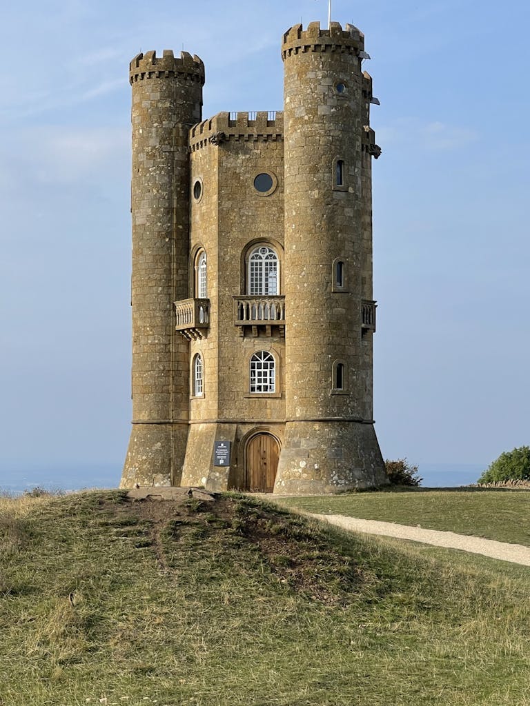 Broadway Tower against a blue sky in Chipping Campden, England, showcasing historic architecture.