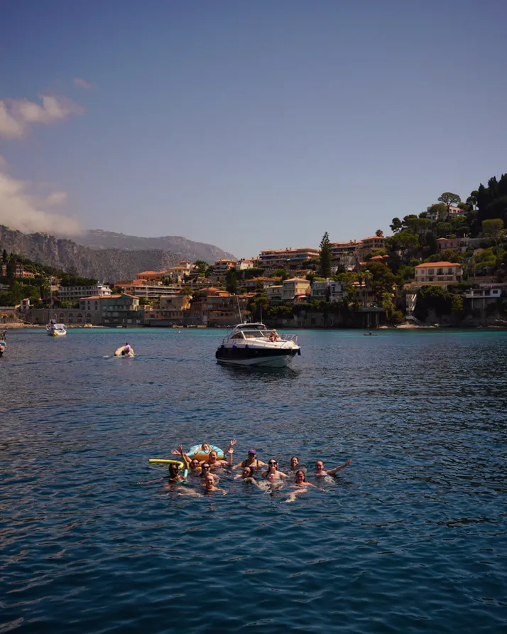 women in the water with a small boat behind them
