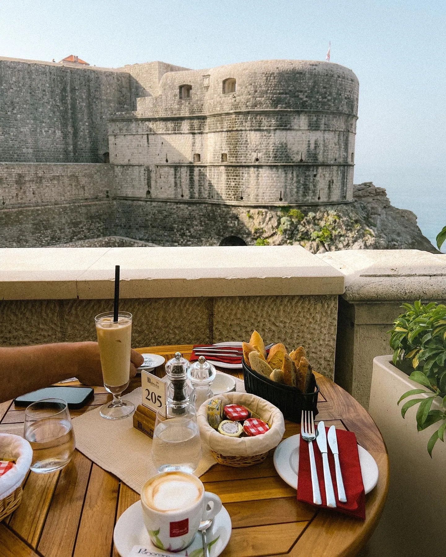table with food overlooking a historical building on a hill