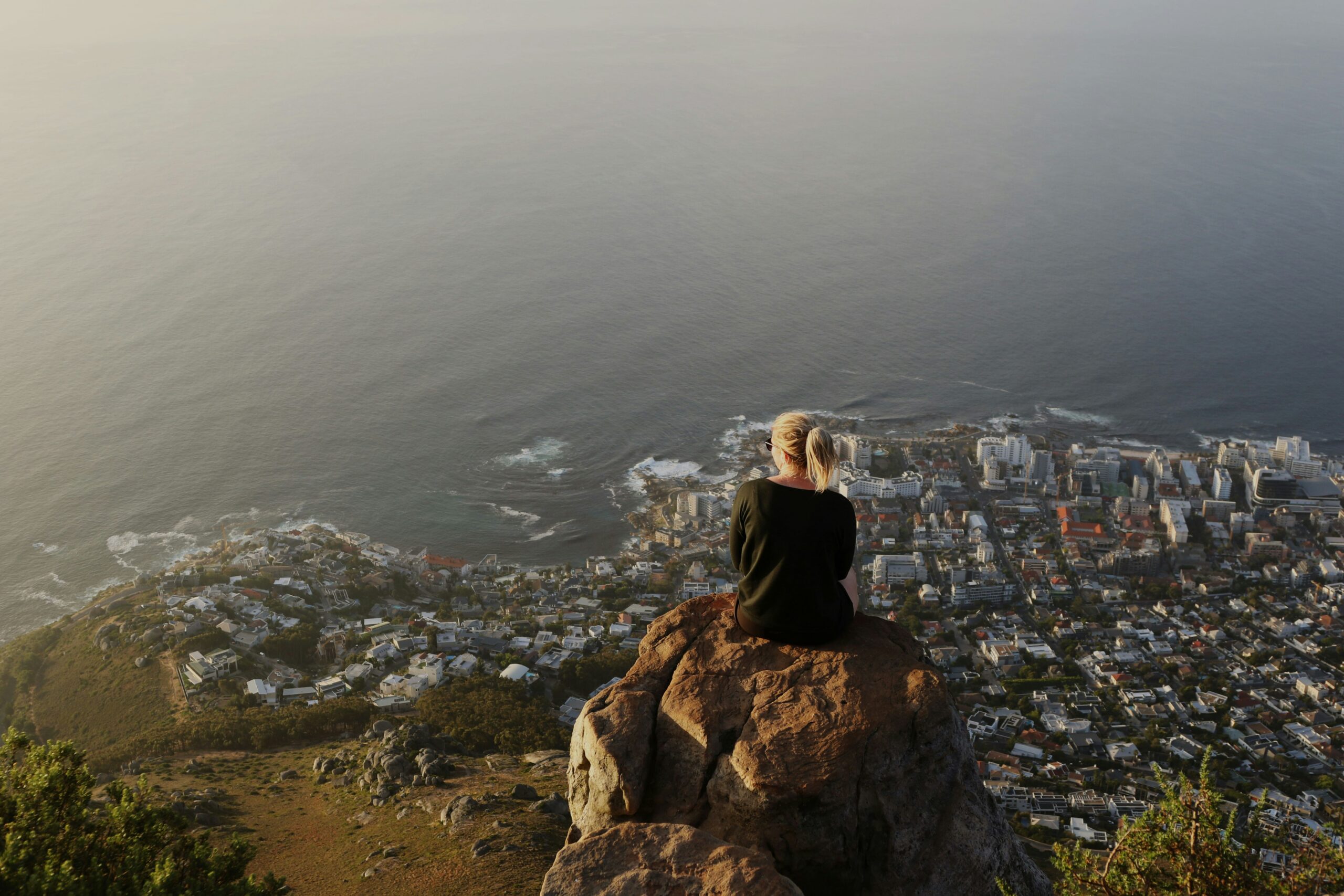 woman sitting on top of a rocky mountain